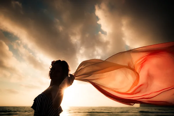 Silhouette einer jungen Frau, die am Strand springt — Stockfoto