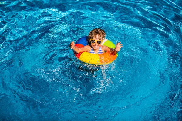 Happy child playing in swimming pool — Stock Photo, Image