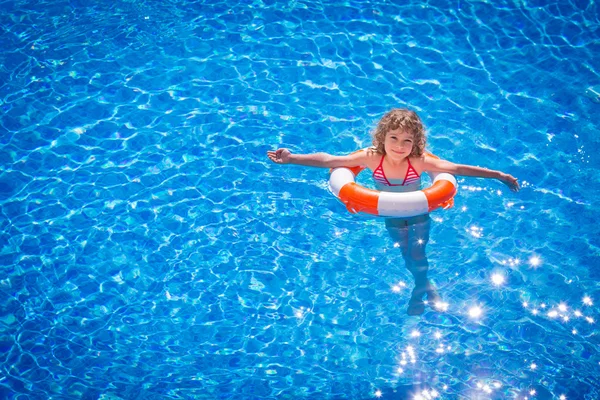 Happy child playing in swimming pool — Stock Photo, Image