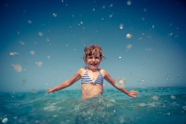 Denizde oynayan mutlu çocuk