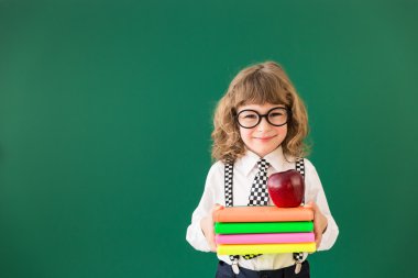 Kitaplar ve elma yığını ile çocuk