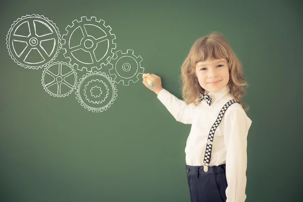 Criança desenho engrenagens na classe — Fotografia de Stock