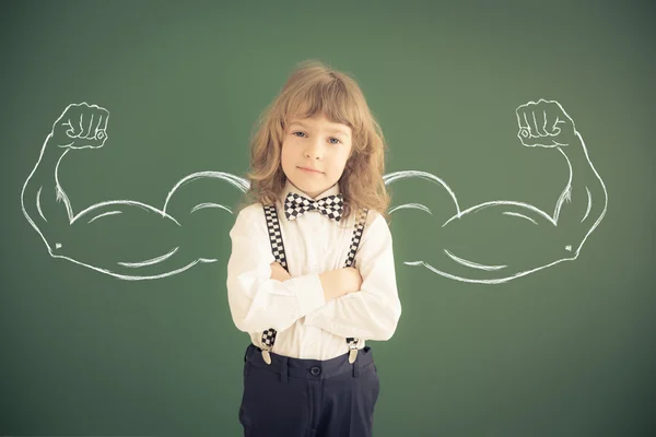 Schooljong geitje met getekende sterke handen — Stockfoto