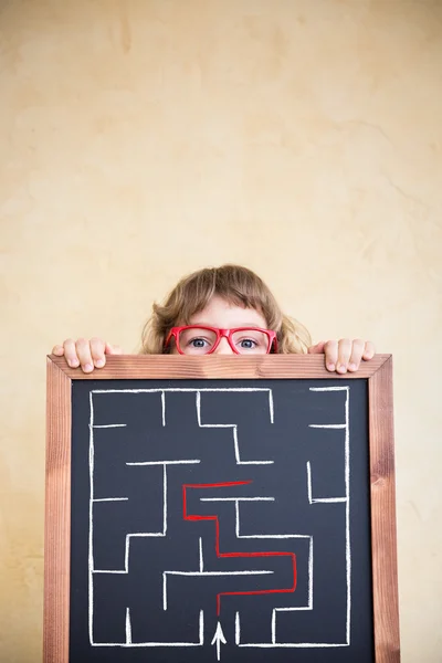 Kid holding blackboard  labyrinth — Stock Photo, Image