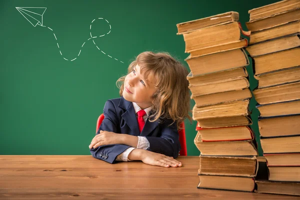 Школьник со стопкой книг — стоковое фото