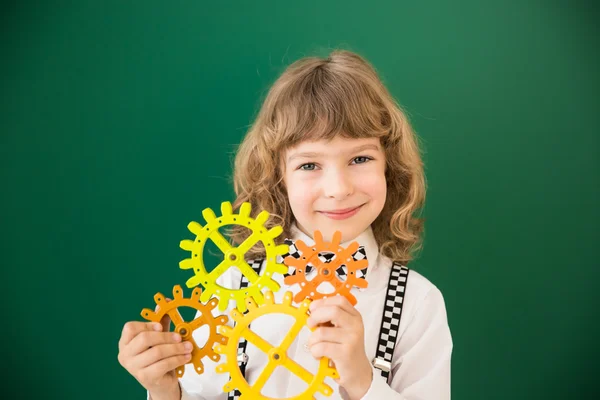 Schulkind mit Spielzeuggetriebe — Stockfoto