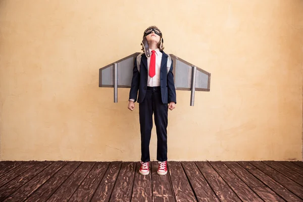 Joven hombre de negocios con alas de papel de juguete — Foto de Stock