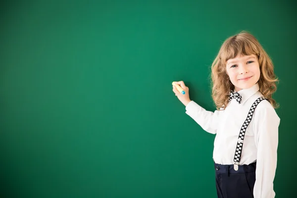 Kid  writing on  blackboard  in class. — Stock Photo, Image