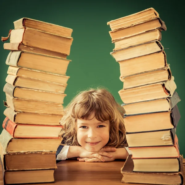 Criança feliz com pilha de livros — Fotografia de Stock