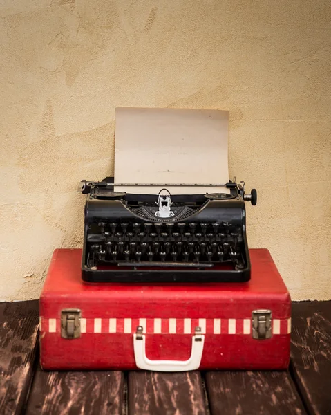 Schrijfmachine en klassieke rode koffer. — Stockfoto
