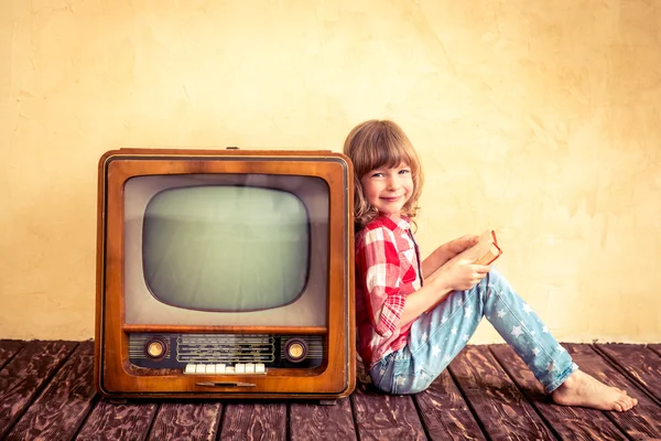 Kid reading the book near retro TV — Stock Photo, Image