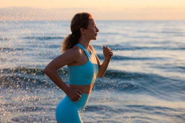 Sportif genç bayan tatil boyunca deniz altyapısına karşı yarışıyor. Kadın antrenman ve kardiyo yapıyor. Sağlık, egzersiz ve yaz sporları eğitimi konsepti