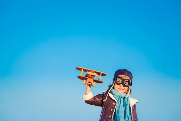 Bambino felice che gioca con aeroplano giocattolo — Foto Stock