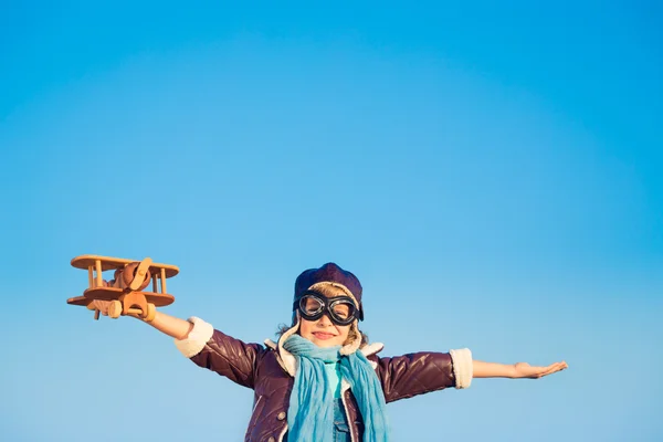 Bambino felice che gioca con aeroplano giocattolo — Foto Stock