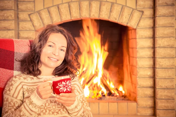 Woman with cup near fireplace — Stock Photo, Image