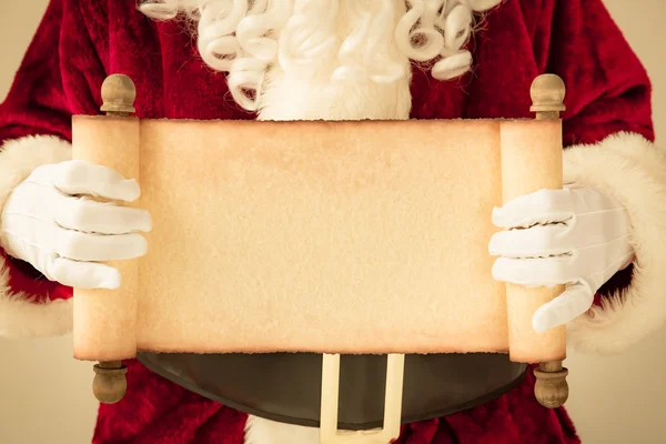 Papai Noel segurando papel de rolagem em branco — Fotografia de Stock