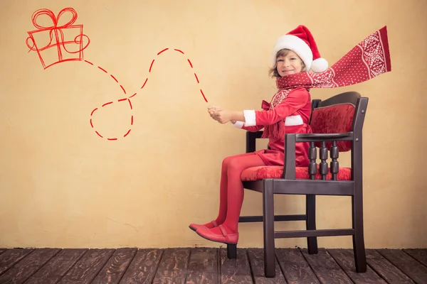 Kind fährt in imaginärem Weihnachtsschlitten — Stockfoto