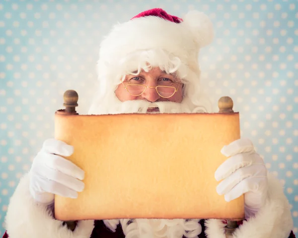 Papá Noel sosteniendo papel de pergamino en blanco — Foto de Stock