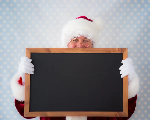 Santa claus segurando quadro negro — Fotografia de Stock