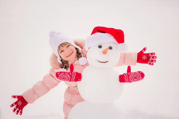 Barn- och snögubbe på vintern — Stockfoto