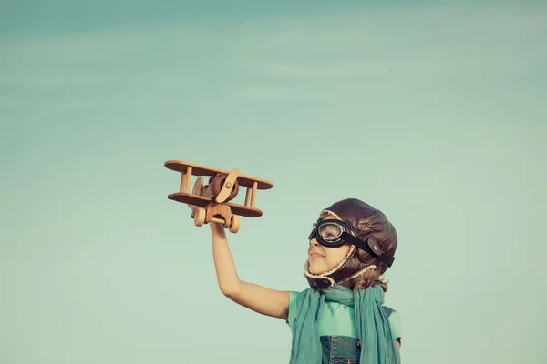 Niño feliz jugando con juguete avión de madera — Foto de Stock