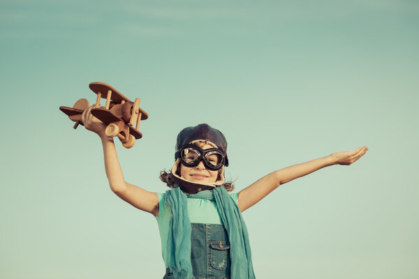 Happy child playing with wooden toy airplane