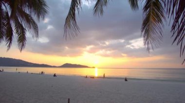 Phuket Tayland. Deniz Sahili. Sahilde Sunset 'in sahnesi. Plajdaki palmiye ağacı Sunset 'teki kum ve deniz ve sahildeki alacakaranlık zamanı. Denizde gün batımı.