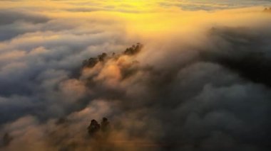 Sabahın ilk ışıklarıyla gökyüzünün hava görüntüsü. Stratüs 'ten bir sis denizi oluşur. Bulutların üstünde. Düz yüzey. Bulutlu, güneşli bir gün karışık vazthill antenleri. Doğa ve seyahat