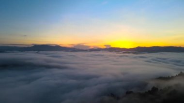 4 bin. Sabahın erken saatlerinde hava manzarası. Güneş doğarken sis veya bulutlar. Bulutların üzerinde gün doğumu manzarası. Güzel yüzey. Bulutlu, güneşli bir gün karışık vazthill havası.