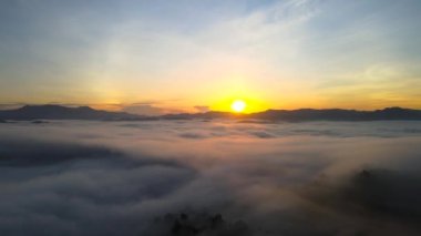 4 bin. Sabahın erken saatlerinde hava manzarası. Güneş doğarken sis veya bulutlar. Bulutların üzerinde gün doğumu manzarası. Güzel yüzey. Bulutlu, güneşli bir gün karışık vazthill havası.