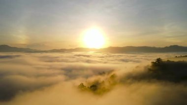 Sabahın ilk ışıklarıyla gökyüzünün hava görüntüsü. Stratüs 'ten bir sis denizi oluşur. Bulutların üstünde. Düz yüzey. Bulutlu, güneşli bir gün karışık vazthill antenleri. Doğa ve seyahat