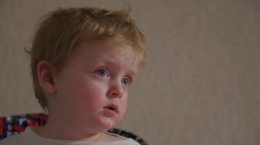 Çizgi film izleyen küçük çocuk.