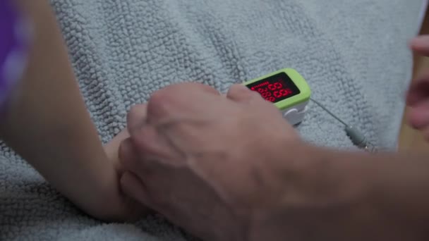 Oximeter på flickans hand — Stockvideo