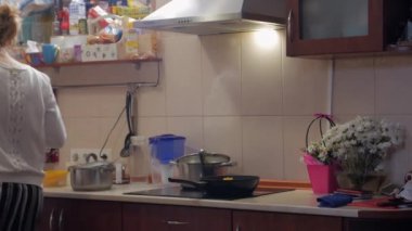 Evde yemek yapan genç bir kadın.