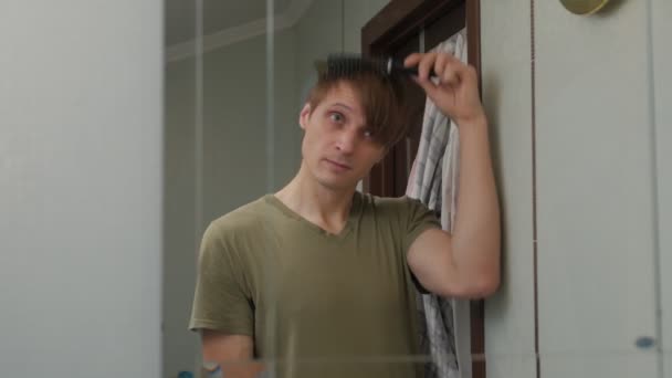 Un hombre peinándose el pelo — Vídeo de stock
