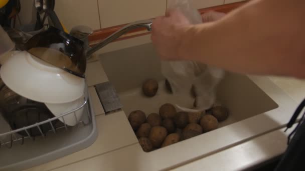 Чоловік миє картоплю — стокове відео