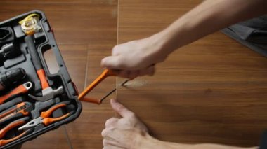 Bir adam bir tahtayı kesti.