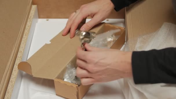 Мужчина открывает коробку с мебелью — стоковое видео