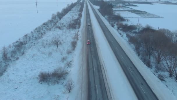 Червона машина на сніговій дорозі — стокове відео