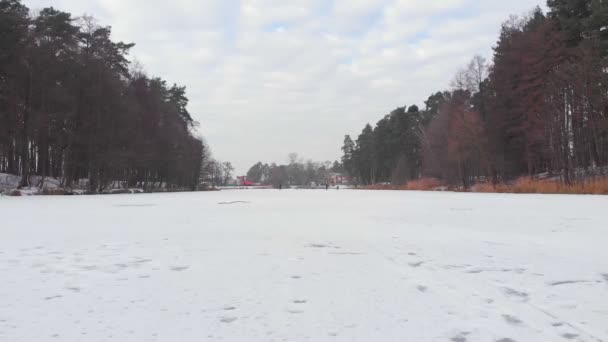 Menschen laufen gefrorenen Fluss entlang — Stockvideo