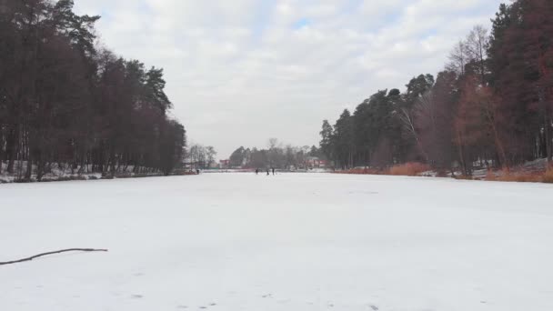 Menschen laufen auf gefrorenem See — Stockvideo
