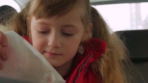 Petite fille manger dans la voiture — Video