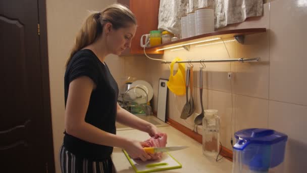 Mujer joven corta carne — Vídeos de Stock