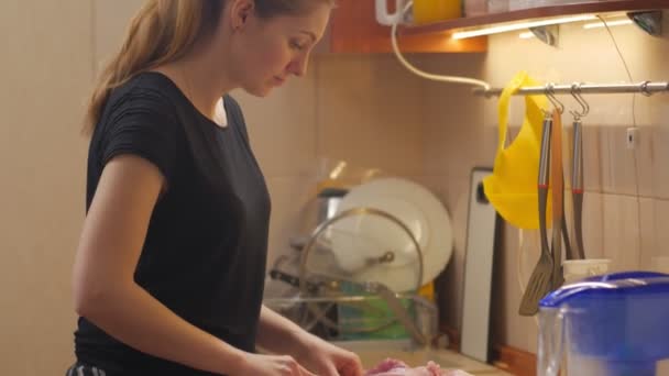 Mujer joven cocinando carne cruda — Vídeos de Stock