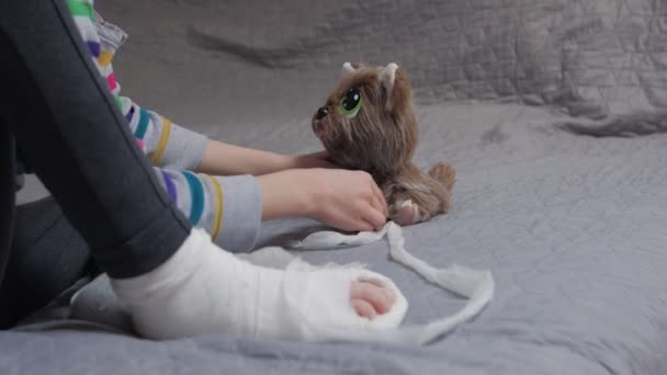 Criança menina bandagens brinquedo do cão — Vídeo de Stock