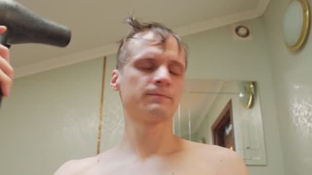 Hombre se seca el cabello húmedo — Vídeo de stock