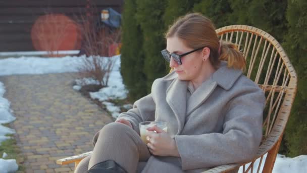 Kobieta w bujanym fotelu z kawą — Wideo stockowe