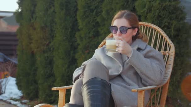Mulher em cadeira de balanço beber café — Vídeo de Stock