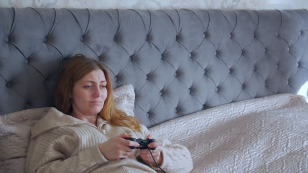 침대에서 컴퓨터 게임을 하는 여자 — 비디오