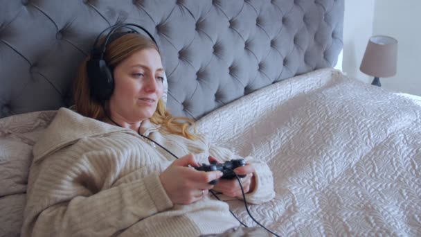 Frau liegt und spielt Videospiele — Stockvideo
